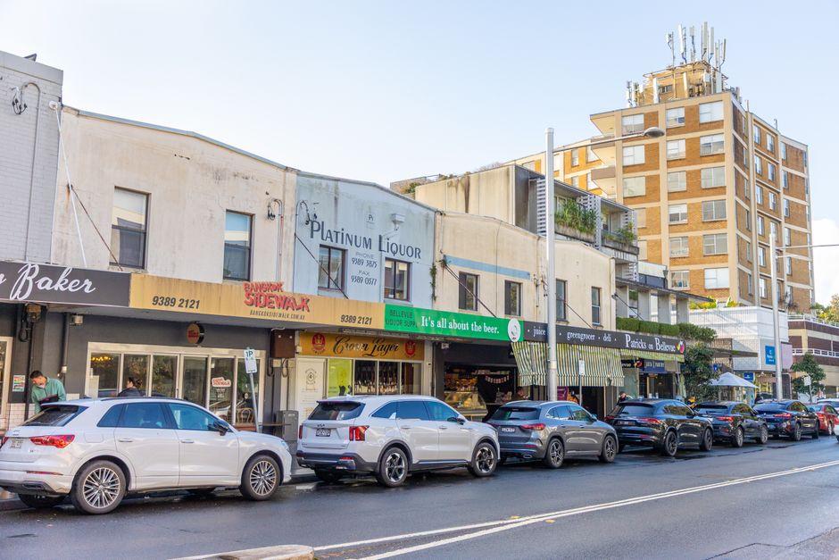Urban Street View with Shops and Vehicles in Sunny Day